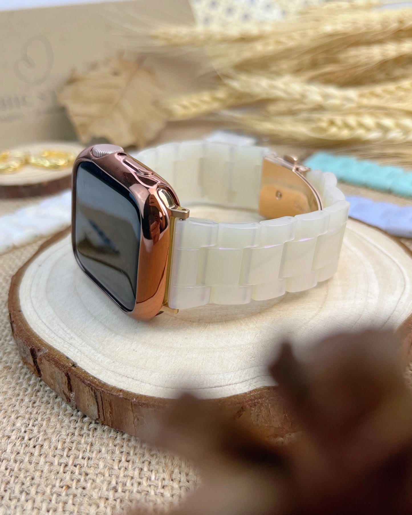 Smartwatch with a white band and rose gold case on a wooden surface