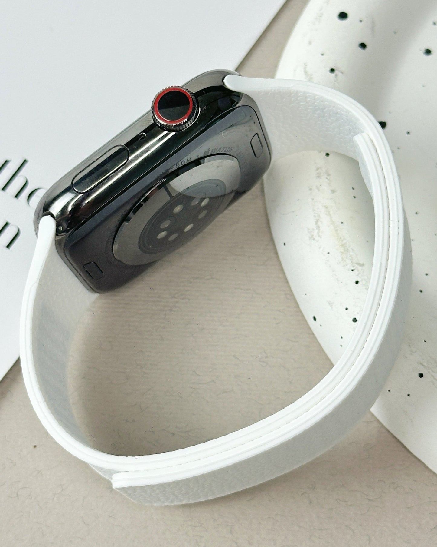 Smartwatch with a white band on a textured surface