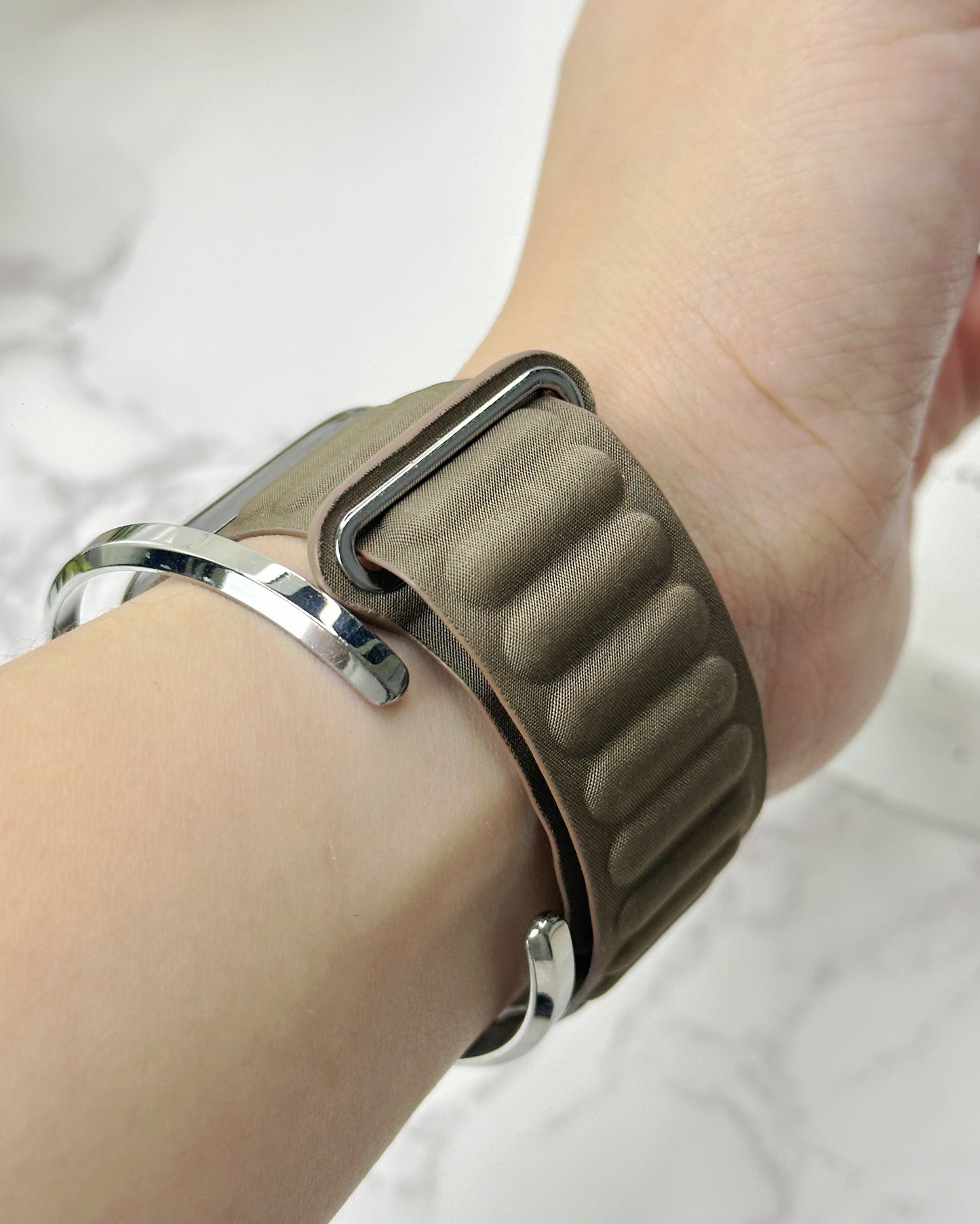 Smartwatch with a brown band on a wrist against a white background
